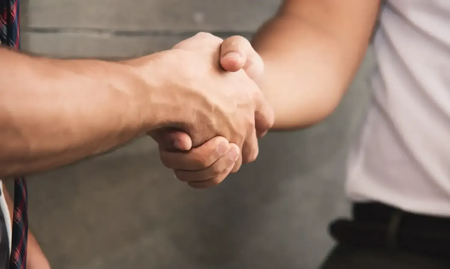 Dos personas dándose la mano, enfatizando un acuerdo o saludo profesional.