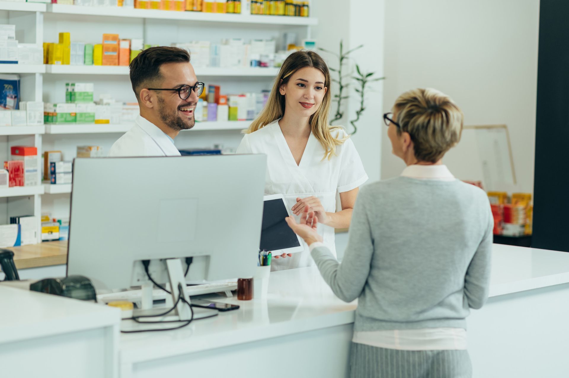 Un médico sostiene un portapapeles en una farmacia.