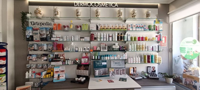 Una farmacéutica sostiene una caja de pastillas en sus manos en una farmacia.