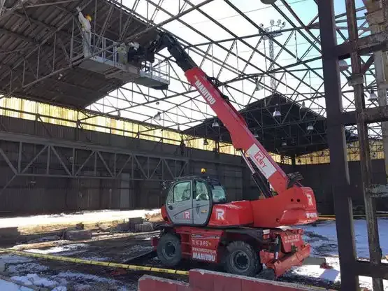 Una grúa roja está trabajando en el tejado de un edificio.