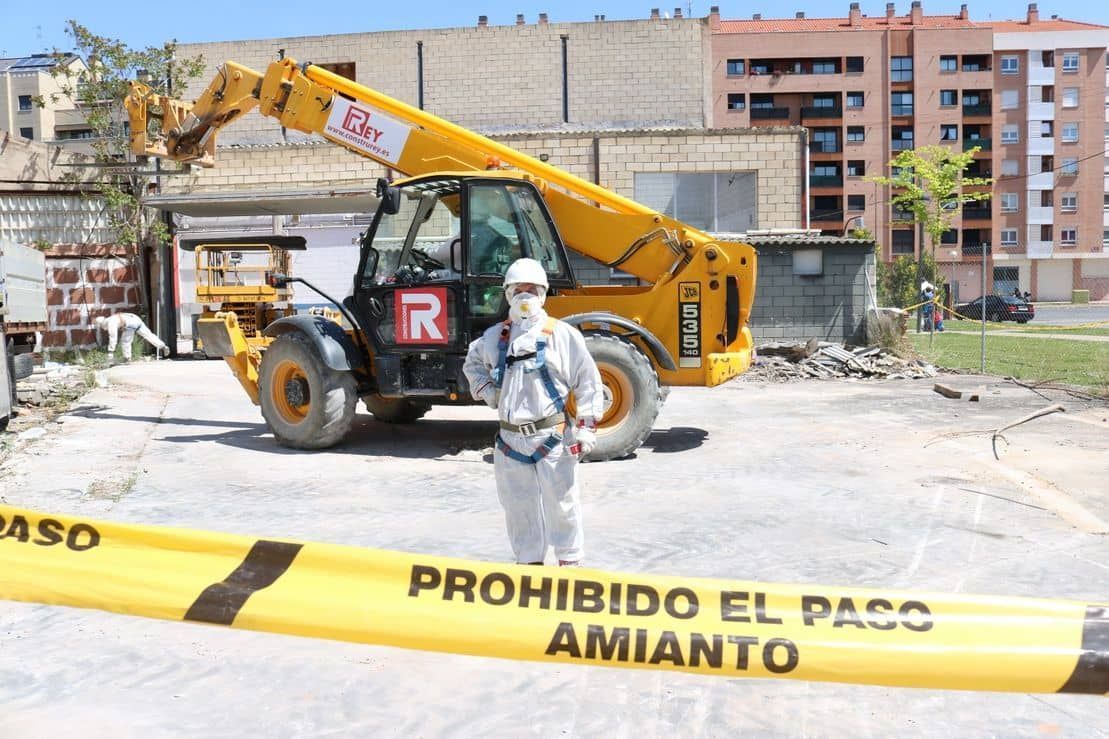 Un hombre parado frente a una cinta amarilla que dice prohibido el paso amianto
