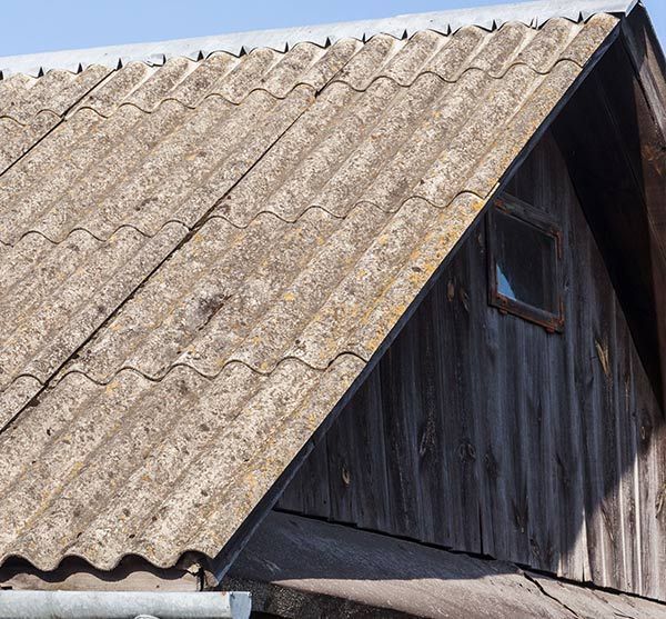 Una casa con un techo de amianto y una ventana