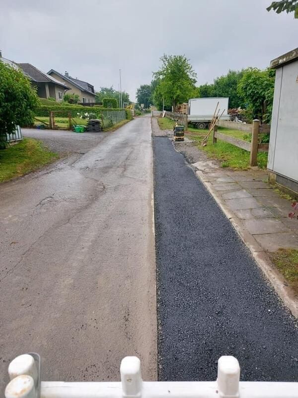 Eine Straße mit einem weißen Zaun an der Seite