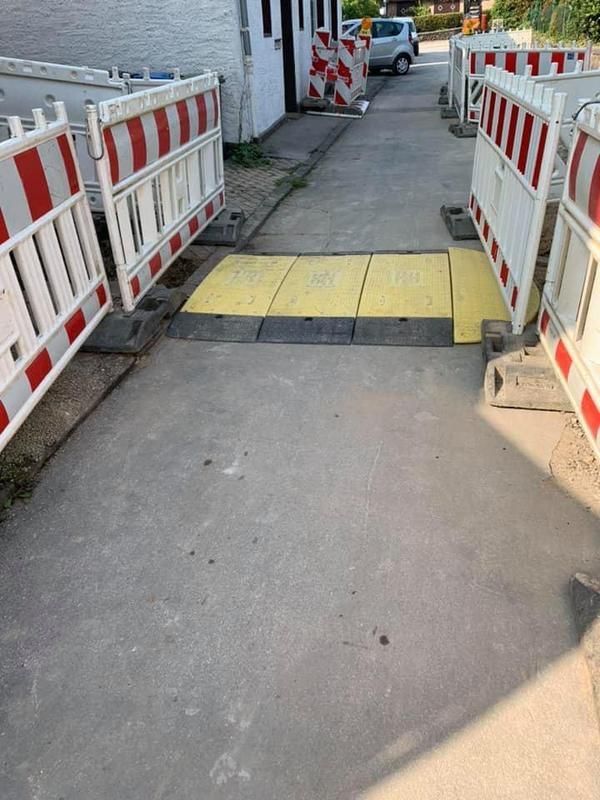 Am Straßenrand befindet sich eine gelbe Barriere.