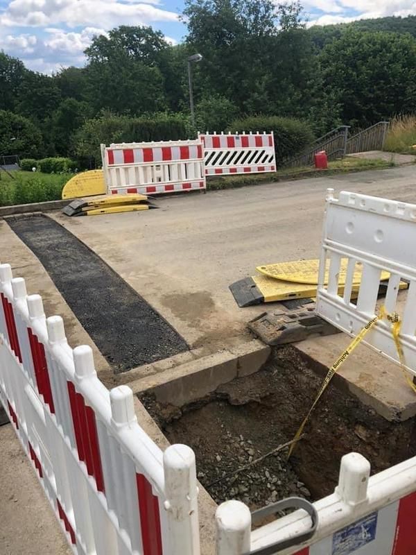 Ein weiß-roter Zaun umgibt ein Loch im Boden.