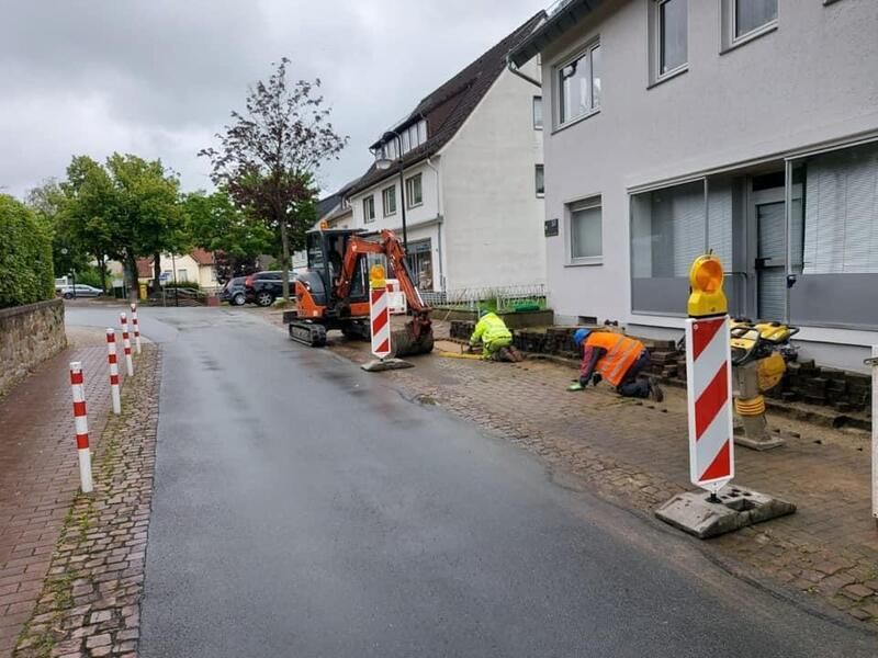 Eine Gruppe Bauarbeiter arbeitet am Straßenrand.