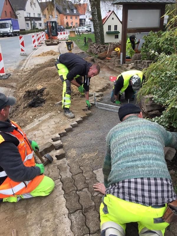 Eine Gruppe von Bauarbeitern arbeitet an einem Gehweg