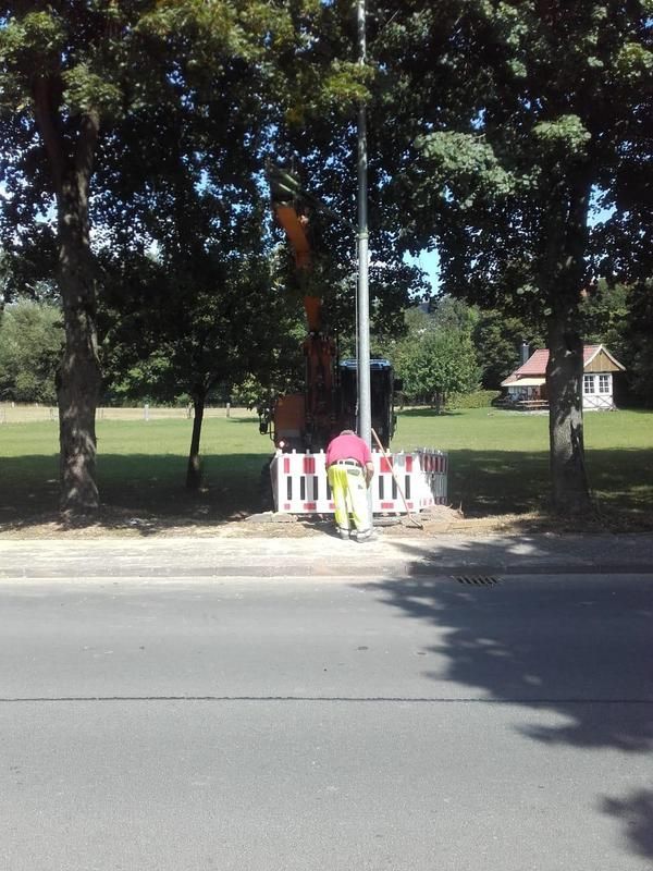 Ein Mann in einem rosa Hemd steht am Straßenrand