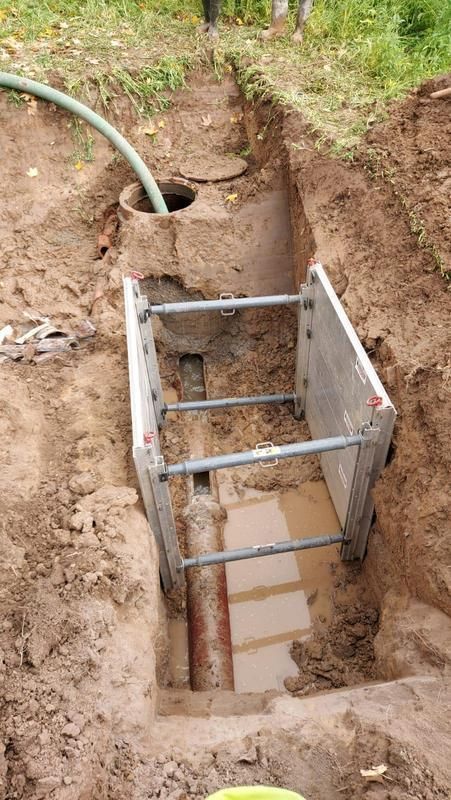 Ein Loch im Boden mit einer Leiter darin und einem Rohr, das herauskommt.