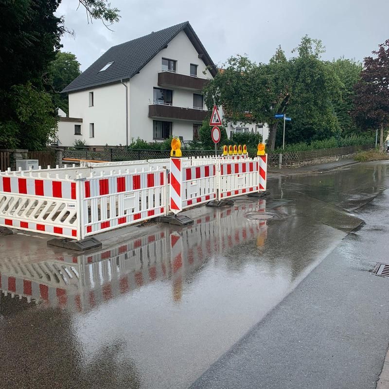 Eine überflutete Straße mit einem weißen Haus im Hintergrund