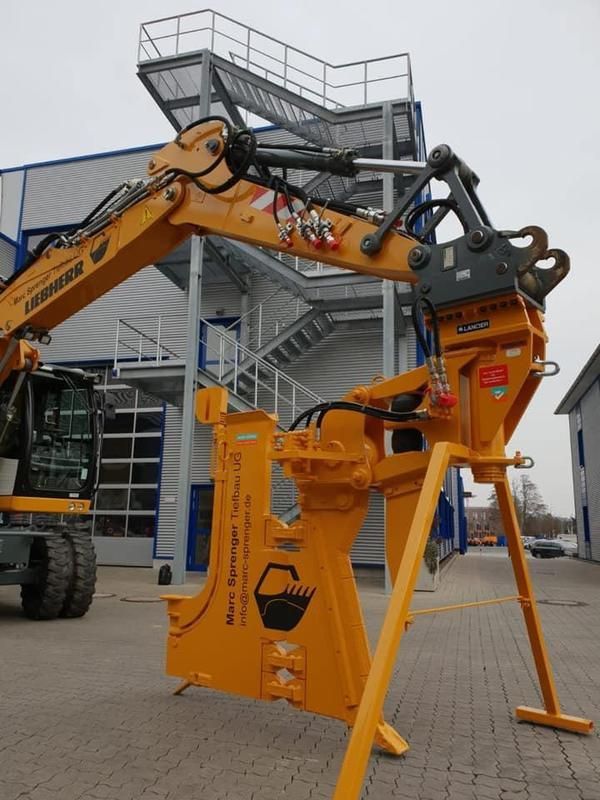 Ein gelber Liebherr-Bagger steht vor einem Gebäude
