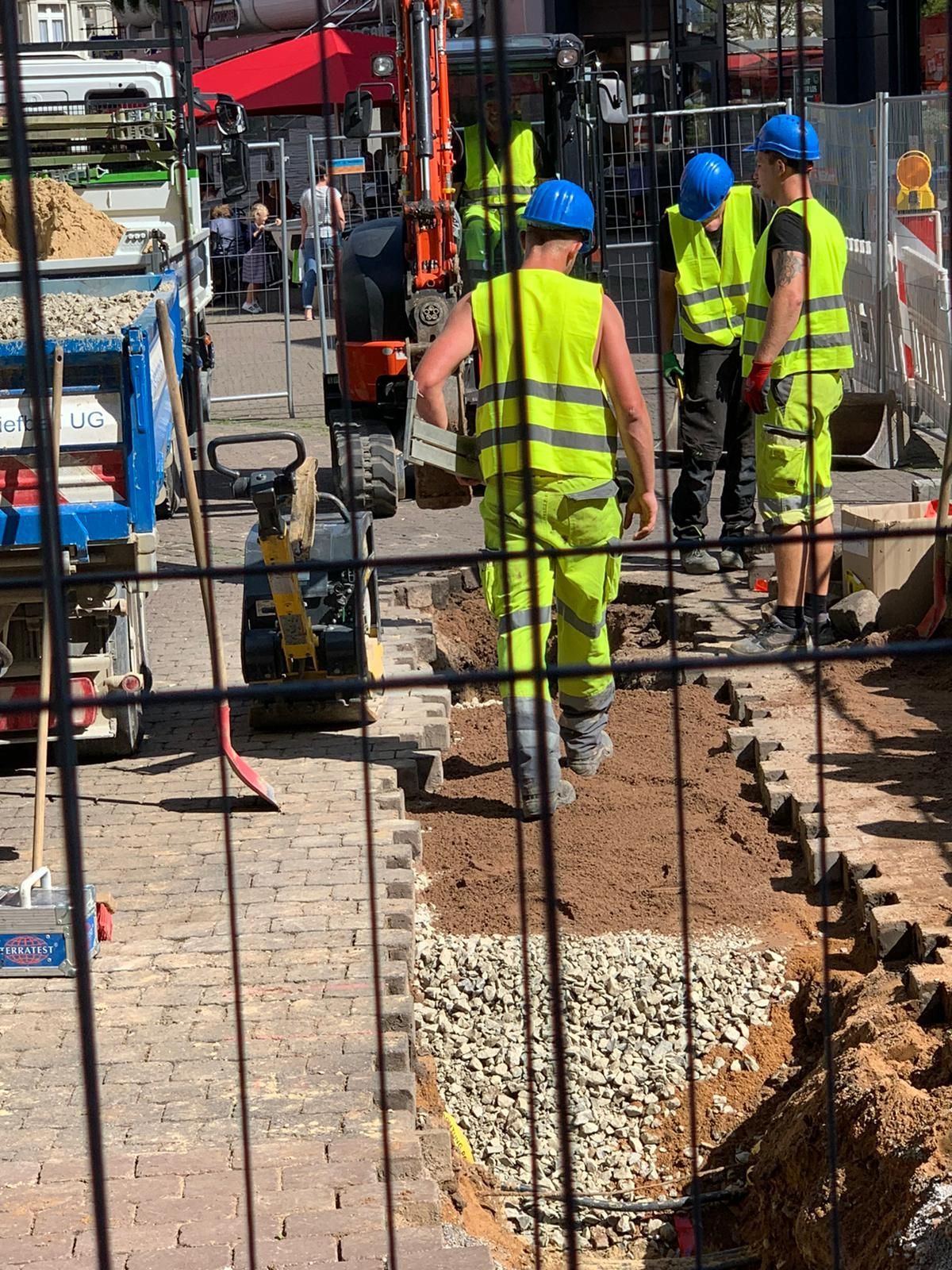 Eine Gruppe Bauarbeiter arbeitet auf einer Straße.