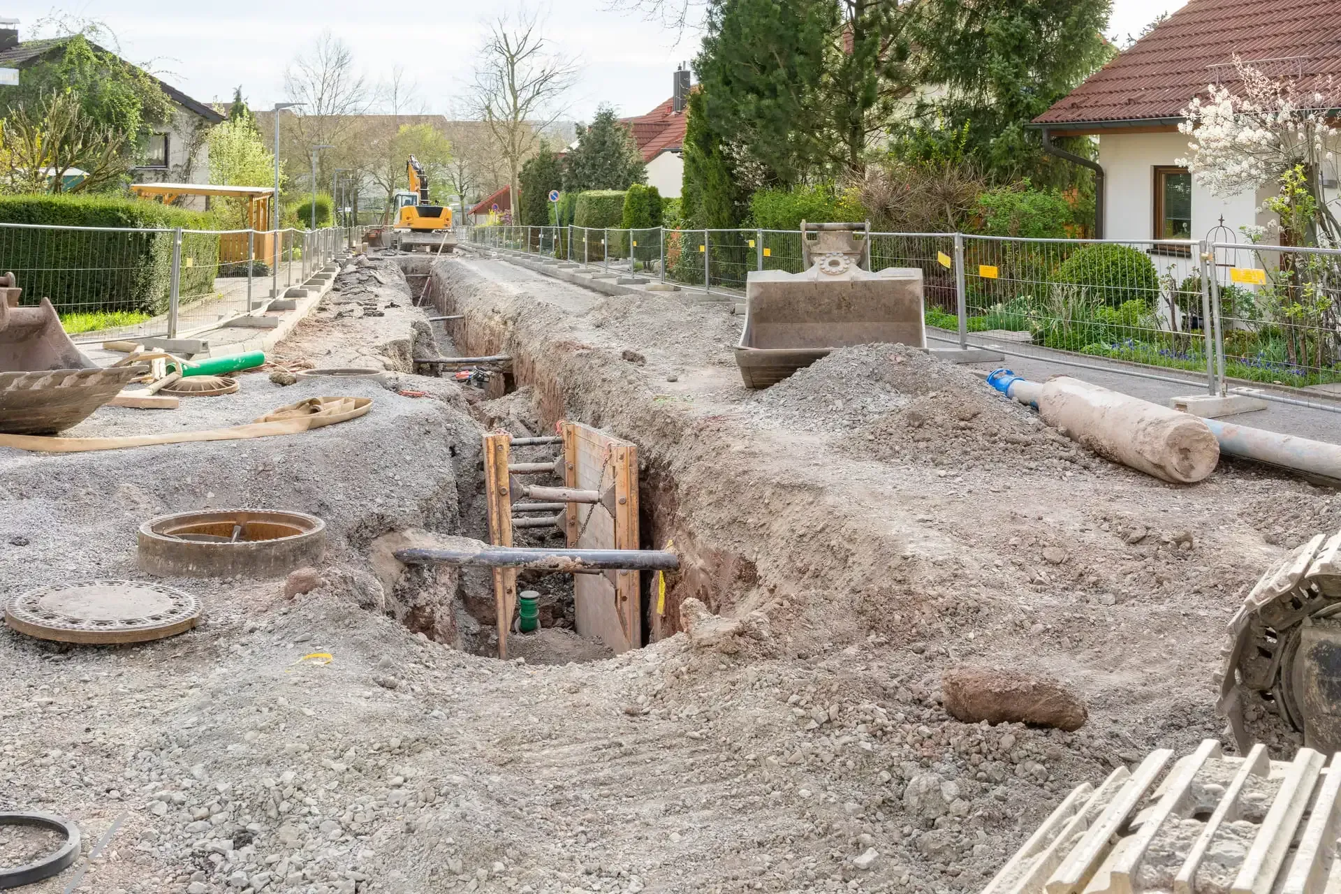 Eine Baustelle mit viel Dreck und einem Haus im Hintergrund.