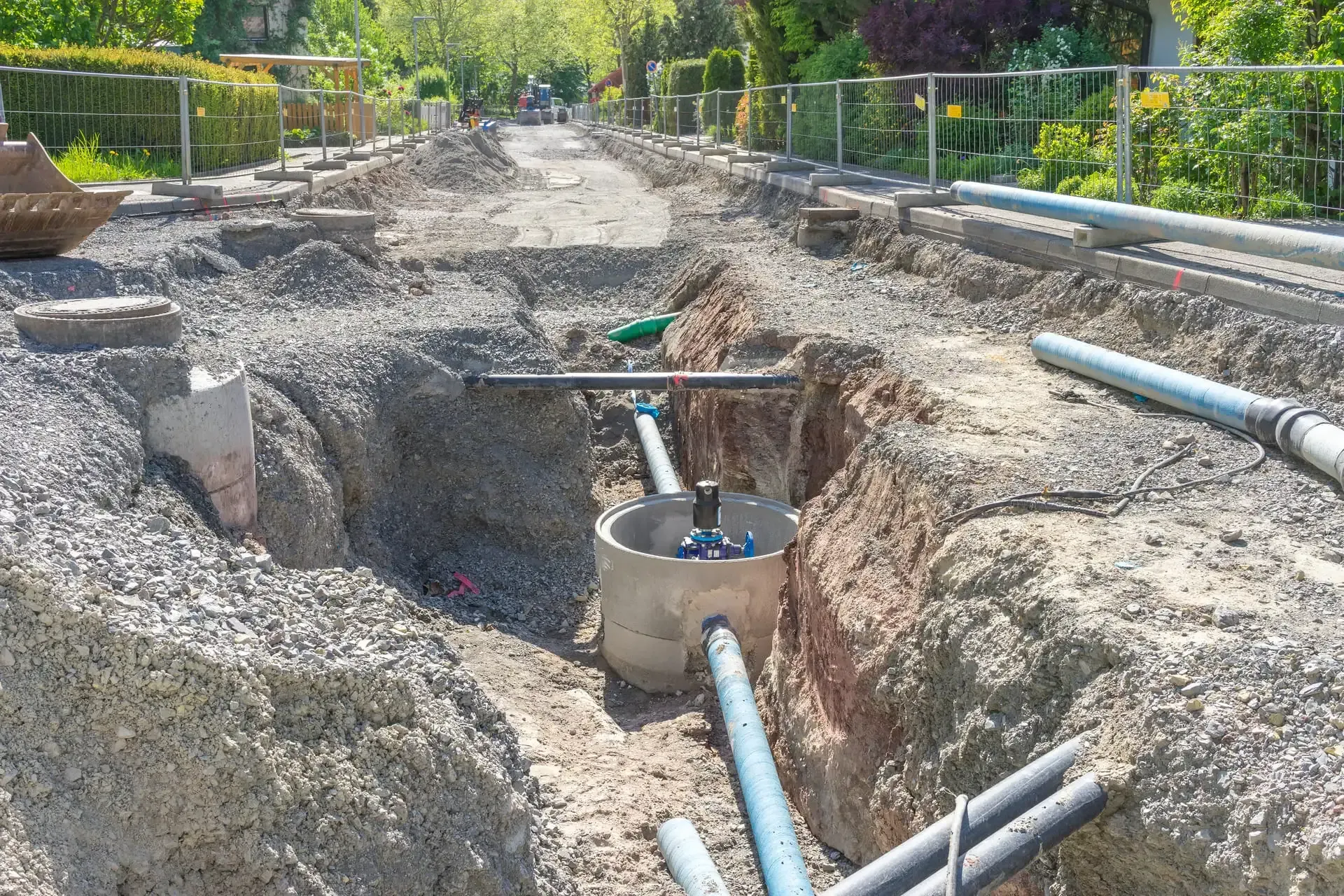 Eine Baustelle mit vielen Rohren im Dreck.