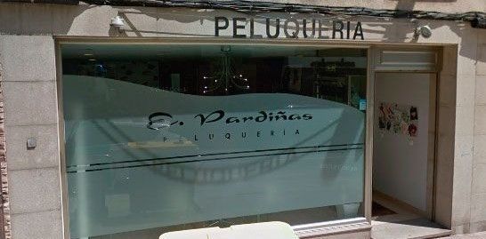 Un escaparate con un cartel que dice peluquería.