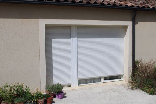 Extérieur d’une maison avec des volets roulants fermés.
