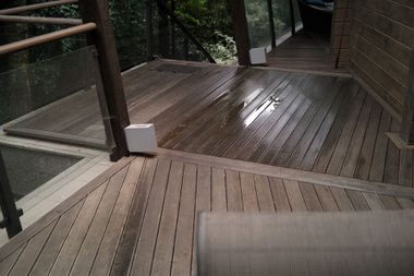 Terrasse en bois mouillée avec un garde-corps.