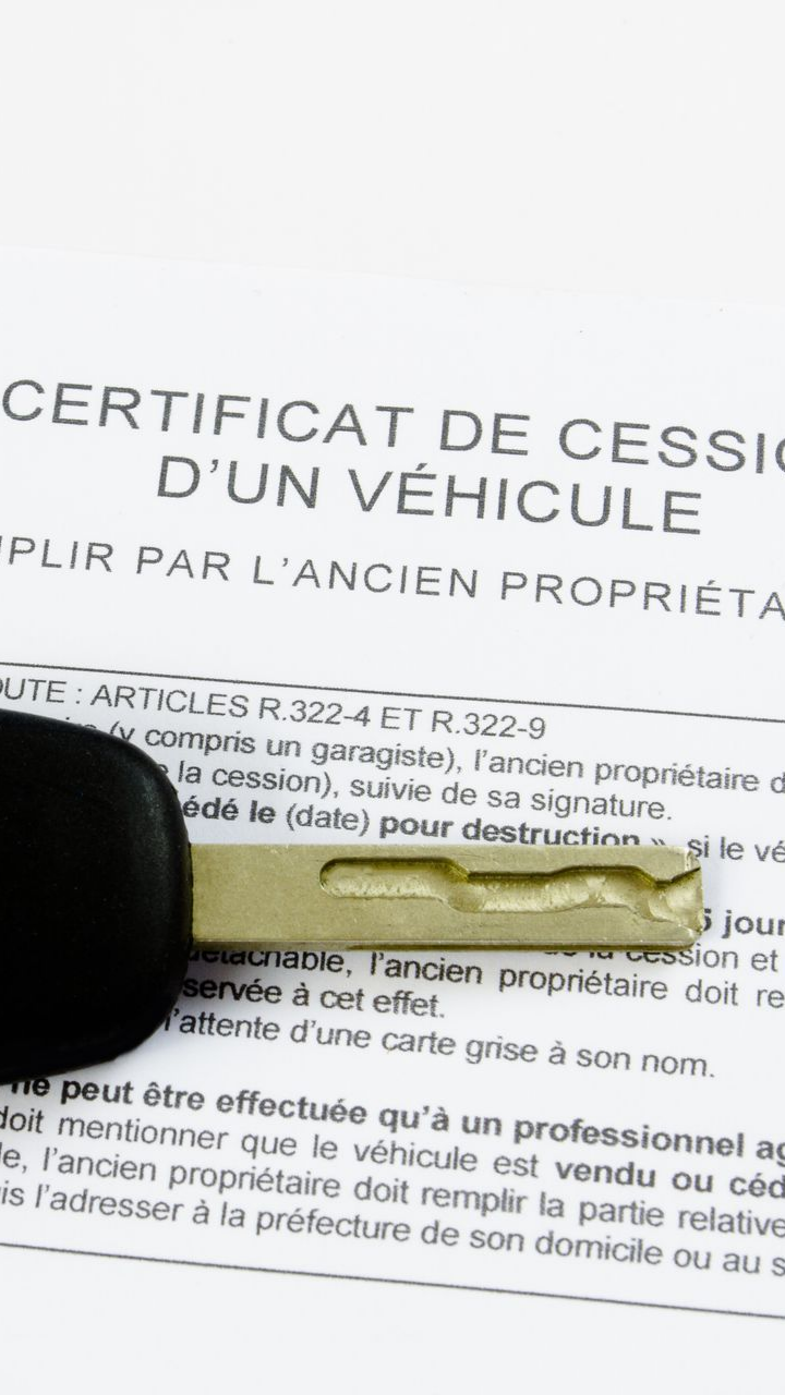 Clé de voiture recouvrant partiellement un certificat de cession de véhicule.