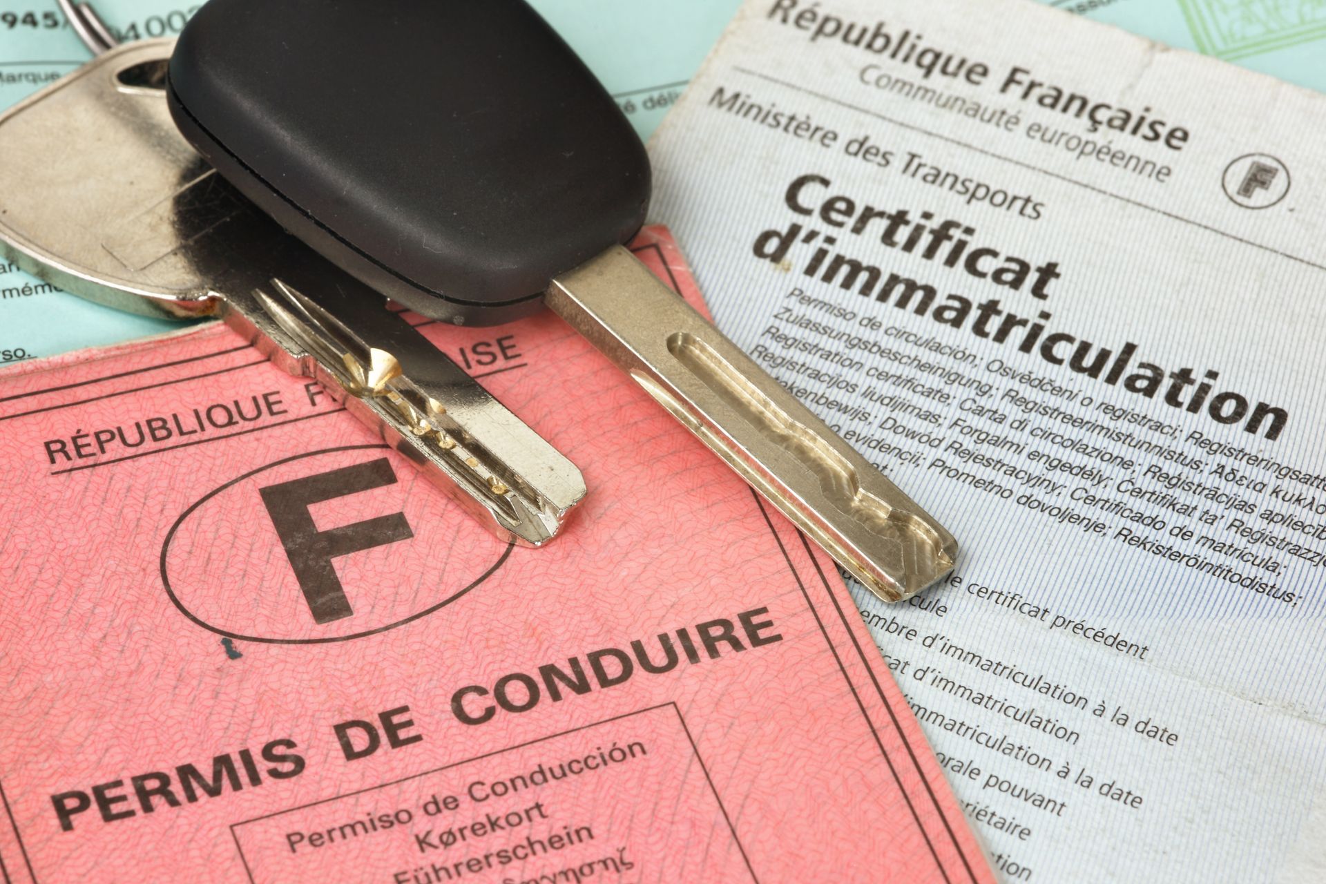 Clés de voiture posées sur un permis de conduire français et un certificat d'immatriculation.