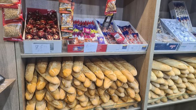 Un estante de panadería lleno de mucho pan y dulces.