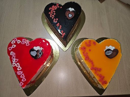 Tres pasteles en forma de corazón están sobre una mesa.