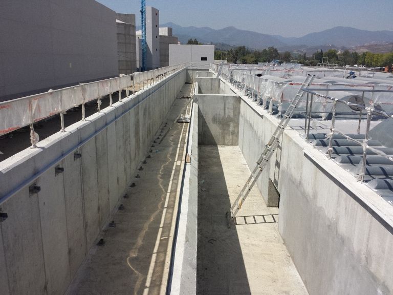 Depósitos de hormigón en una planta de tratamiento de agua, posiblemente en construcción. La luz del sol ilumina .