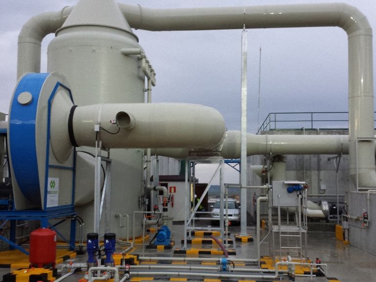 Sistema de filtración de aire industrial sobre plataforma exterior, compuesto por grandes unidades cilíndricas.