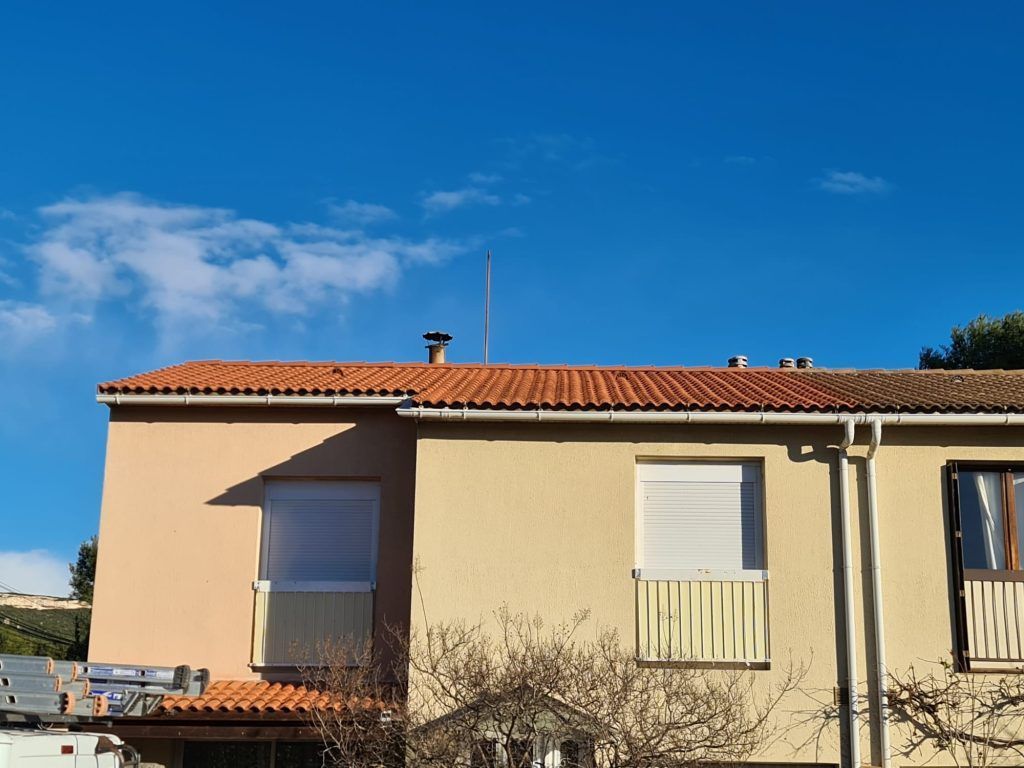 Un immeuble résidentiel beige avec un étage et des tuiles orange