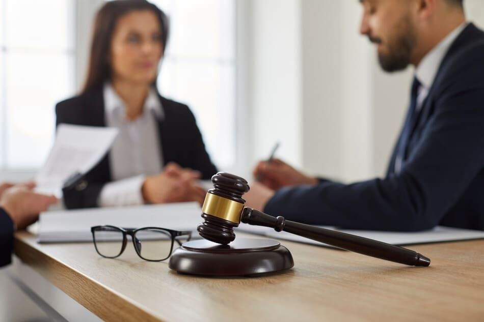Un hombre y una mujer están sentados en una mesa con un mazo sobre ella.