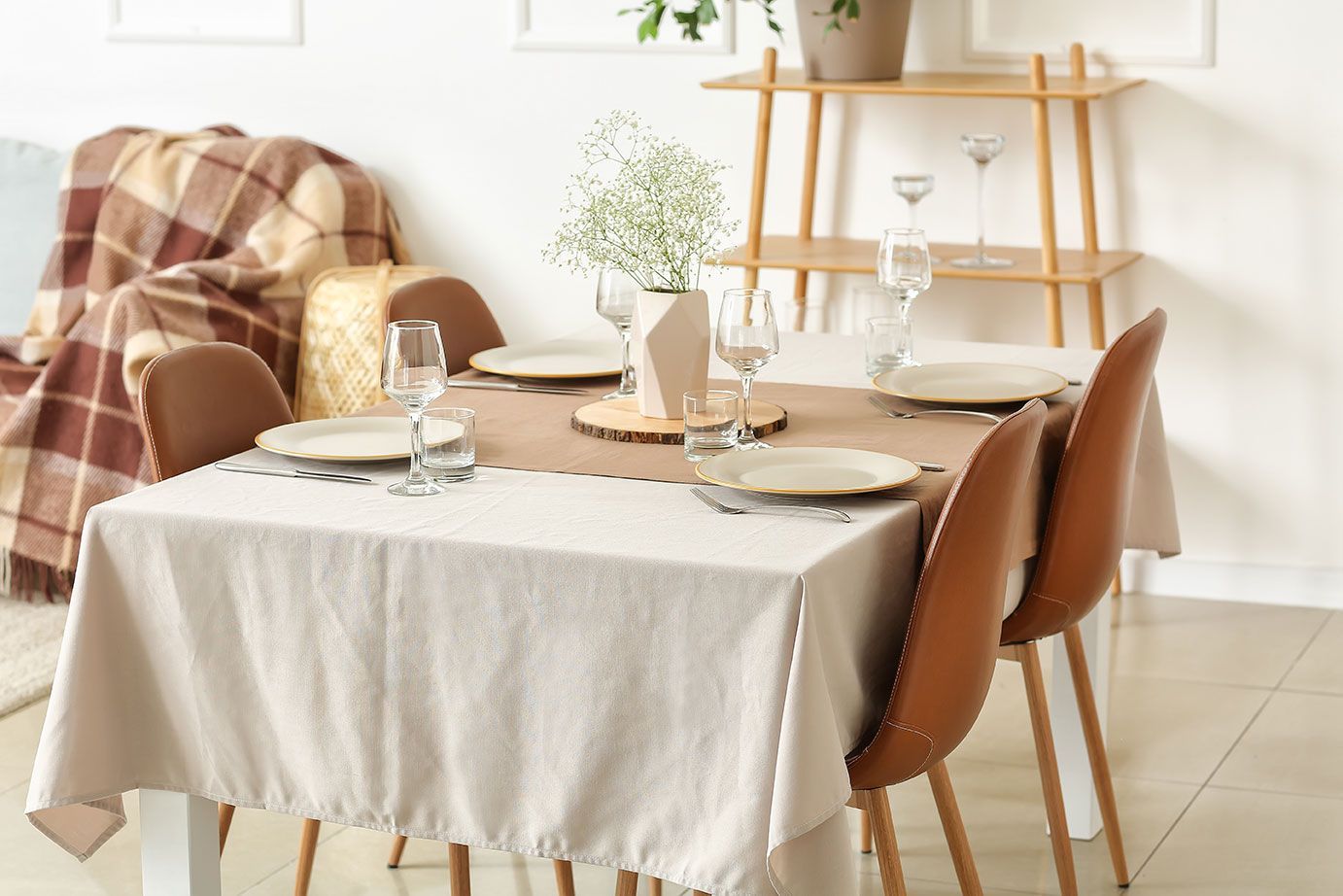 Table avec une nappe blanche et des couverts posés dessus