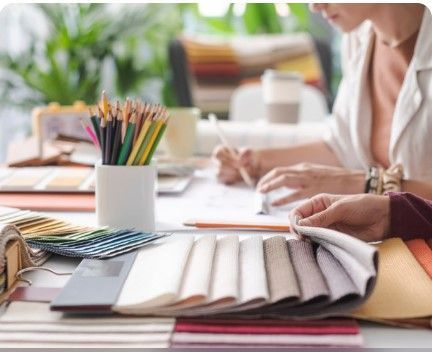 Les décorateurs d'intérieur travaillent avec des échantillons de tissus, des crayons et des palettes de couleurs.
