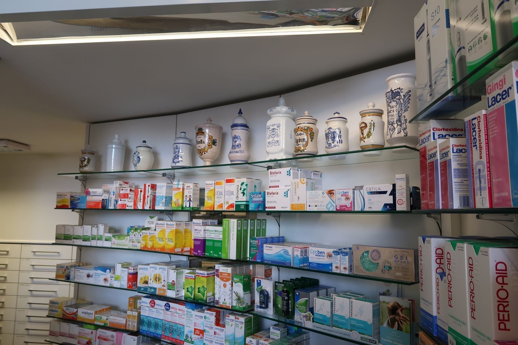 Una farmacia llena de muchos frascos y cajas en los estantes.