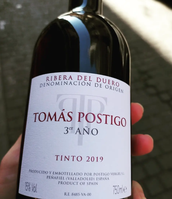 Wine bottle label reading “Tomás Postigo 3º Año Tinto 2019” from Ribera del Duero, held in a hand