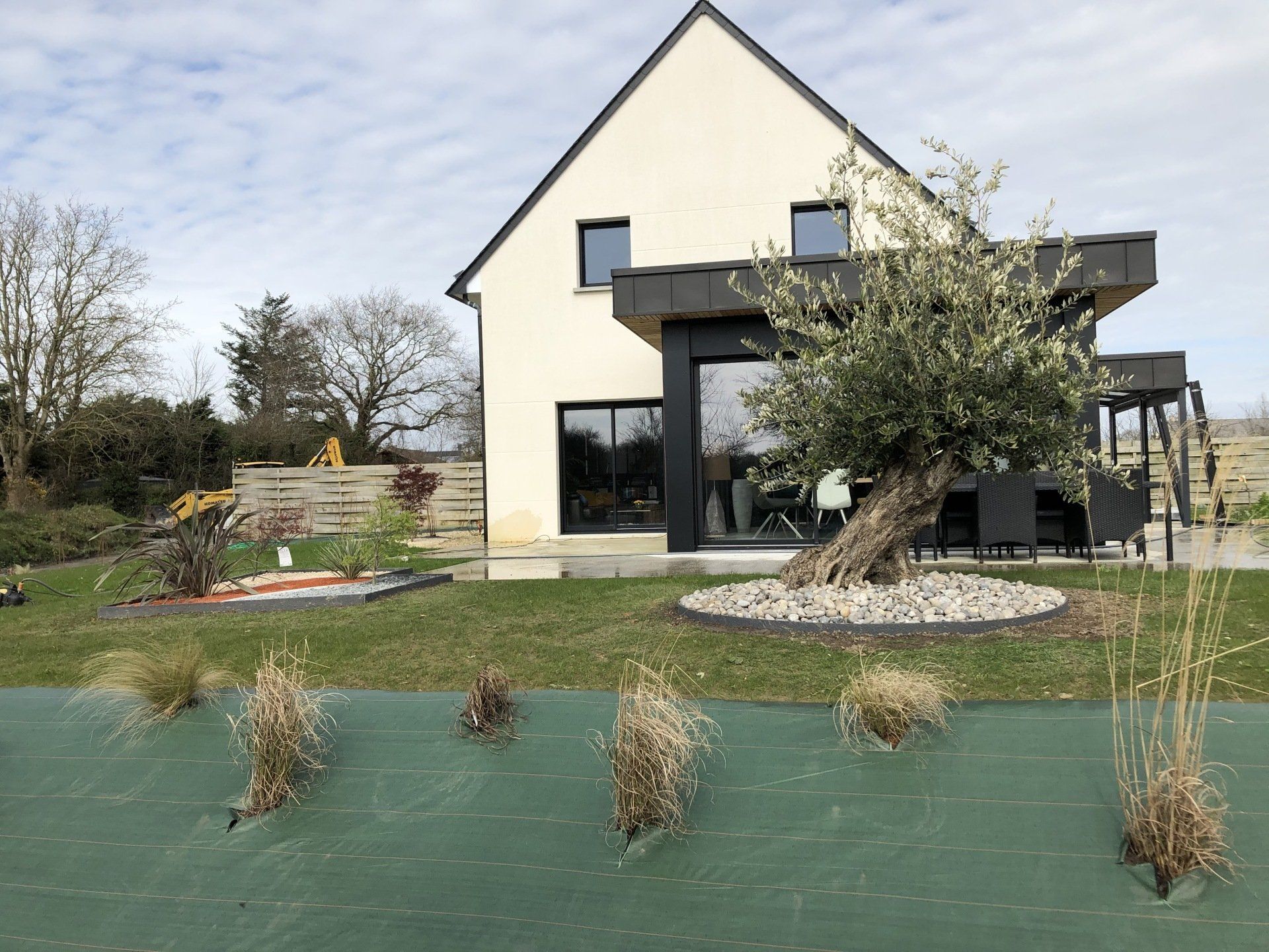 Un massif de plantes devant une maison.
