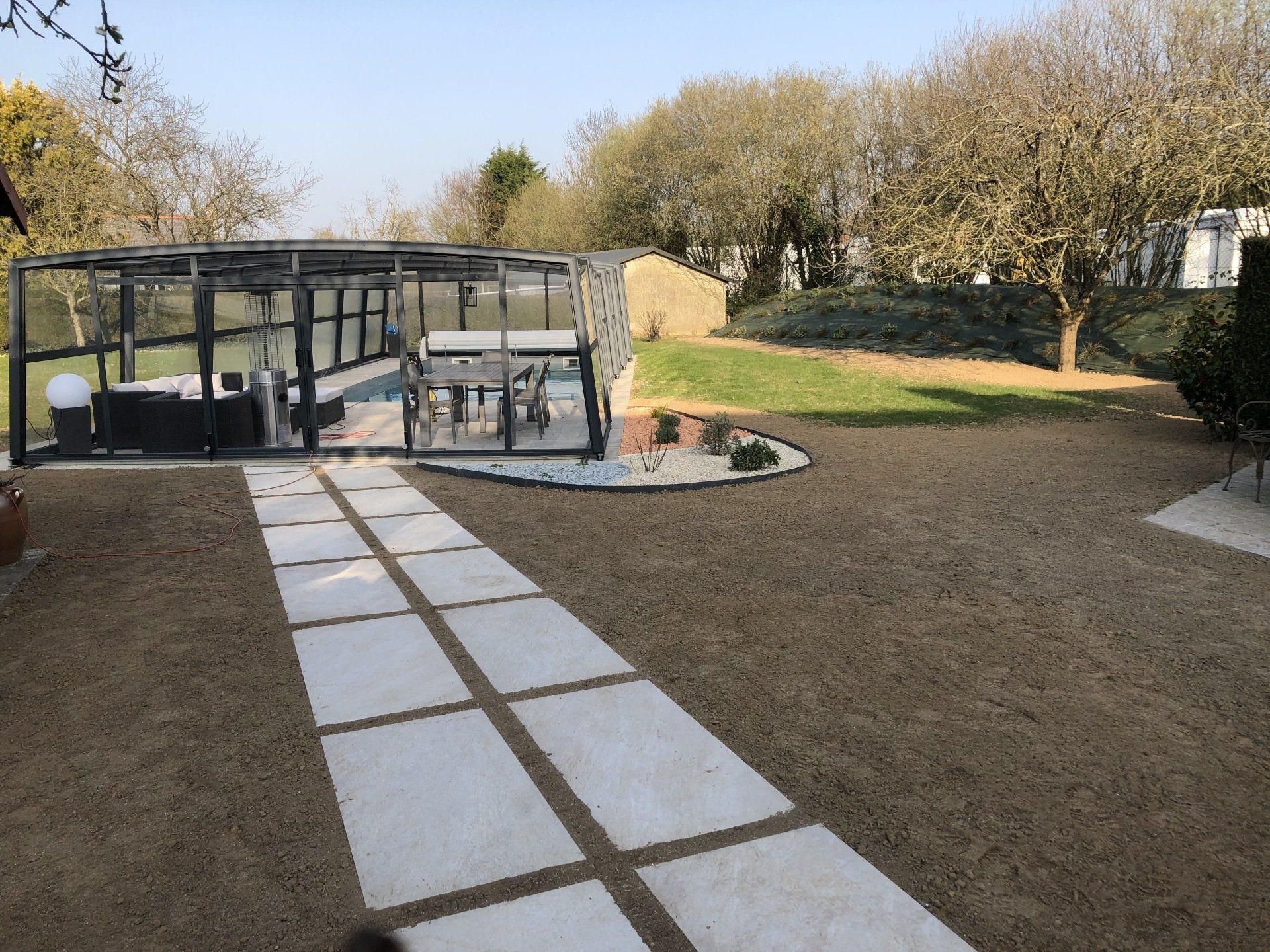 Un chemin de dalles menant vers une terrasse.