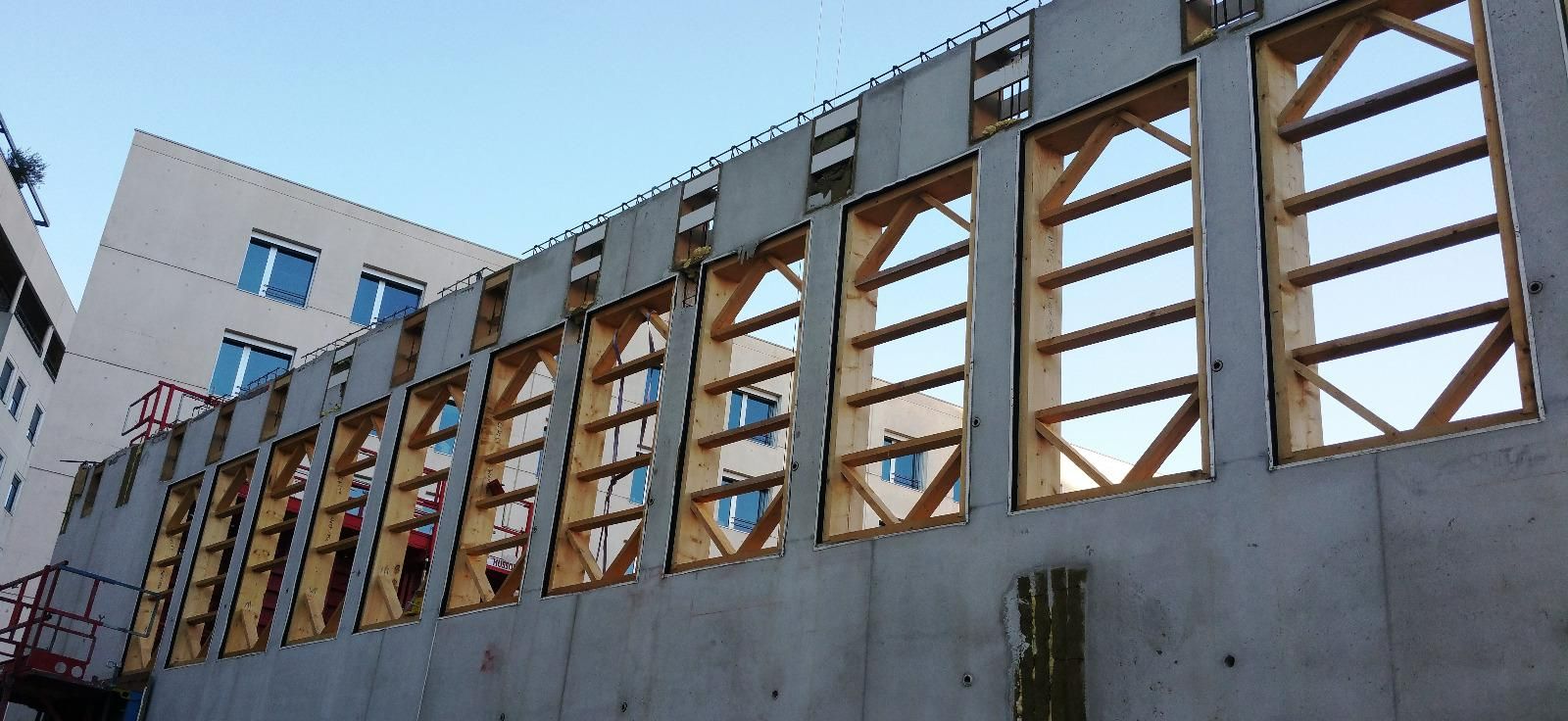 Photo de mannequins pour grandes fenêtres alignées sur un mur béton.