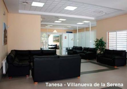 Una sala de estar con muchos sofás y sillas negros.