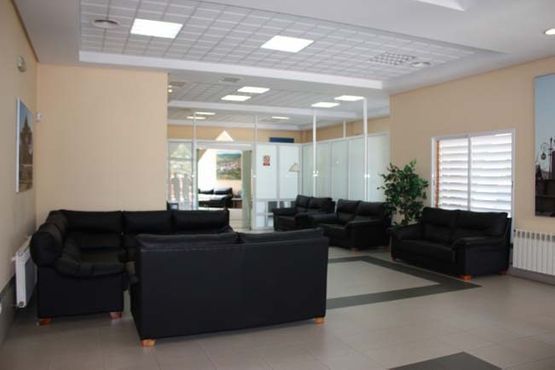 Una sala de estar con muchos sofás y sillas negros.