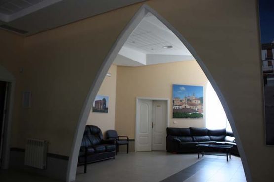 Una sala de estar con un sofá y sillas y un cuadro en la pared.