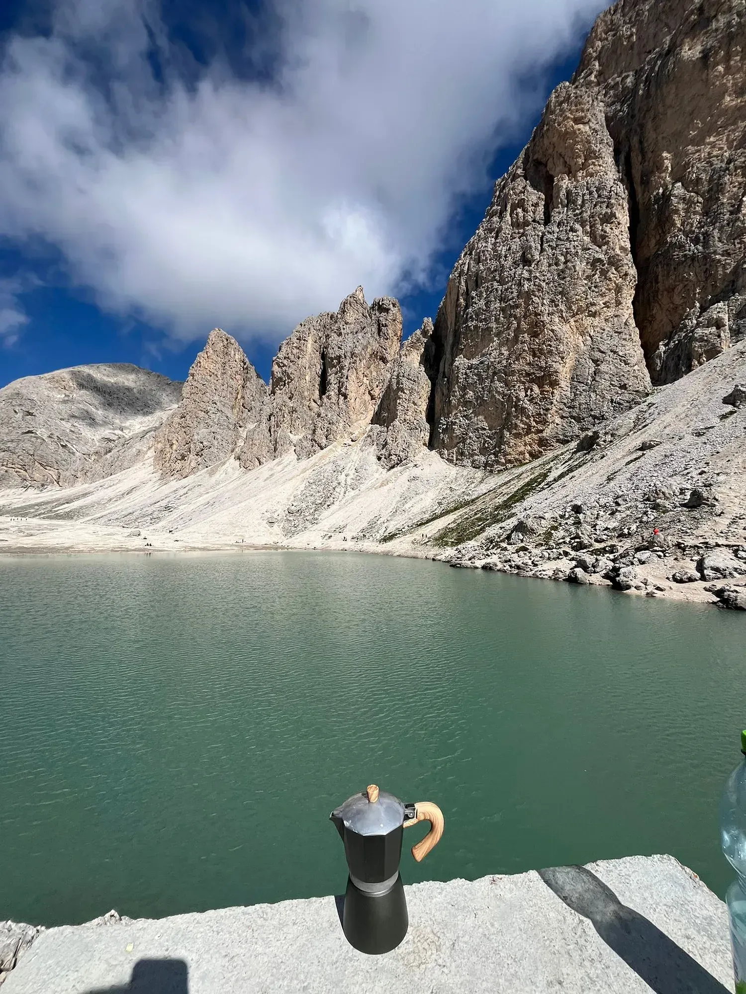 Eine Kaffeekanne steht vor einem See mit Bergen im Hintergrund