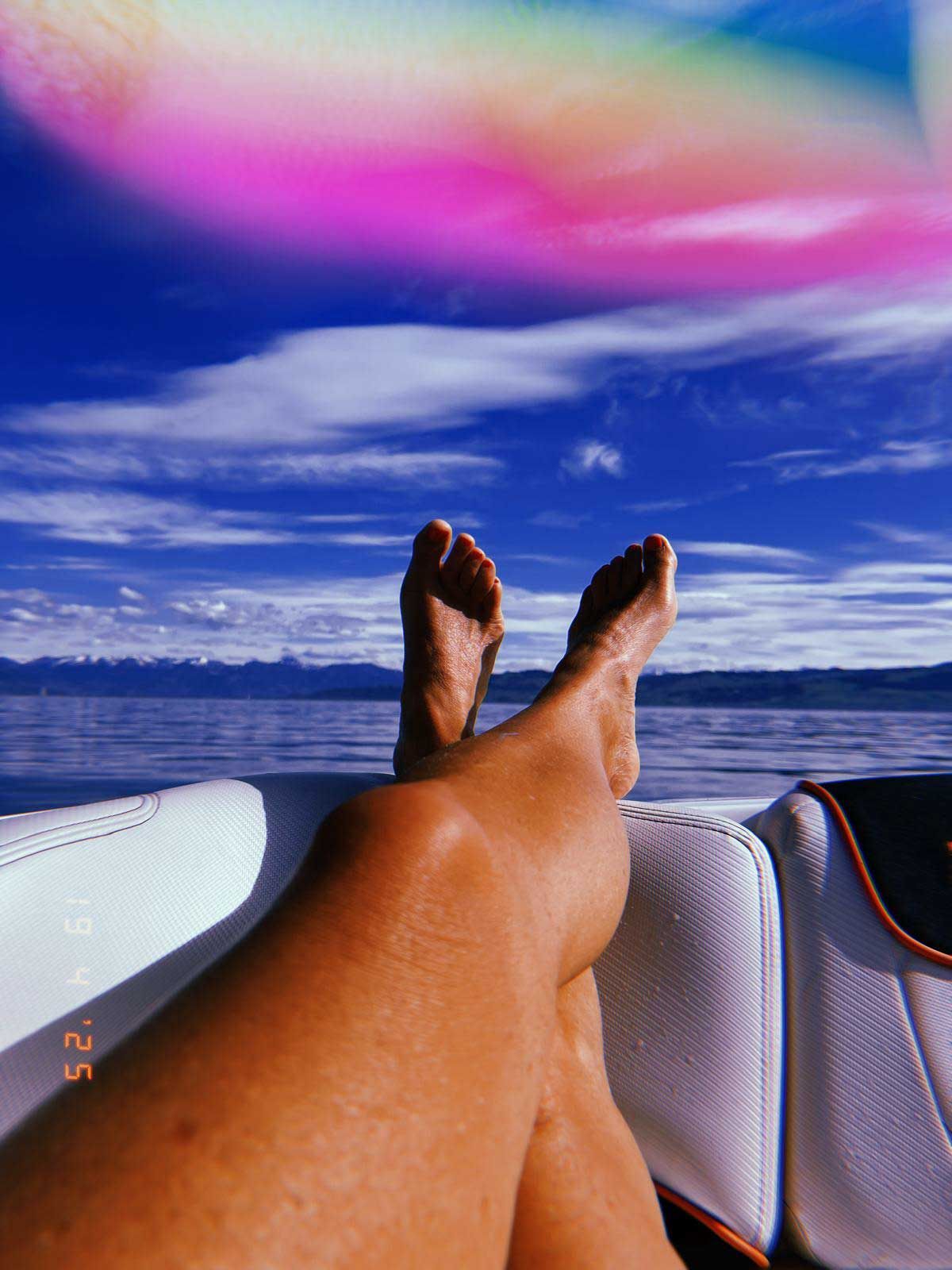 Eine Person, die mit hochgelegten Füßen auf einem Boot liegt