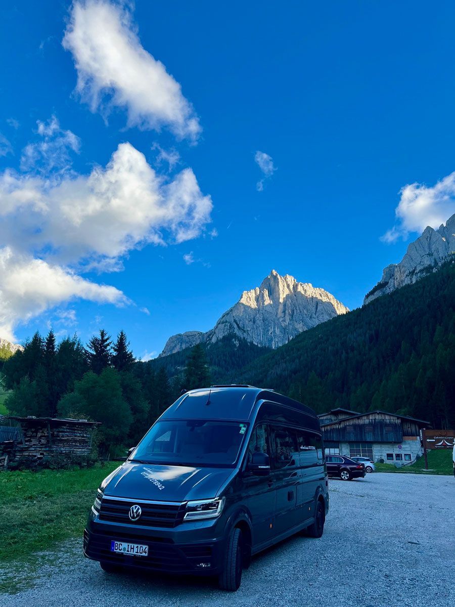 Ein schwarzer Lieferwagen parkt vor einem Berg.