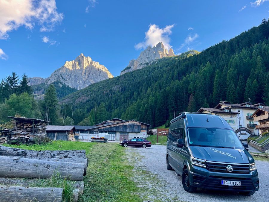 Ein Lieferwagen steht auf einem Parkplatz vor einem Berg.