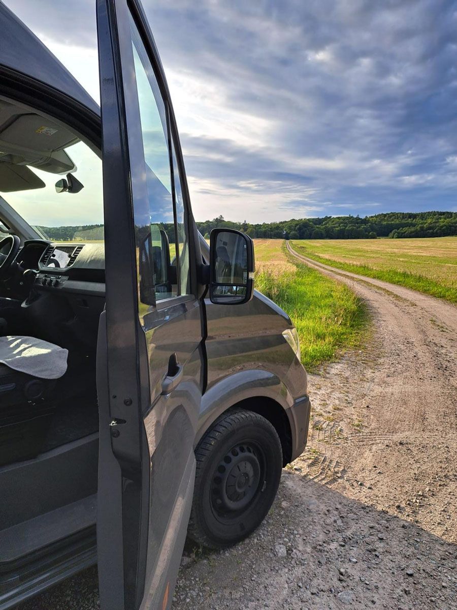 Ein Lieferwagen steht am Rand einer unbefestigten Straße