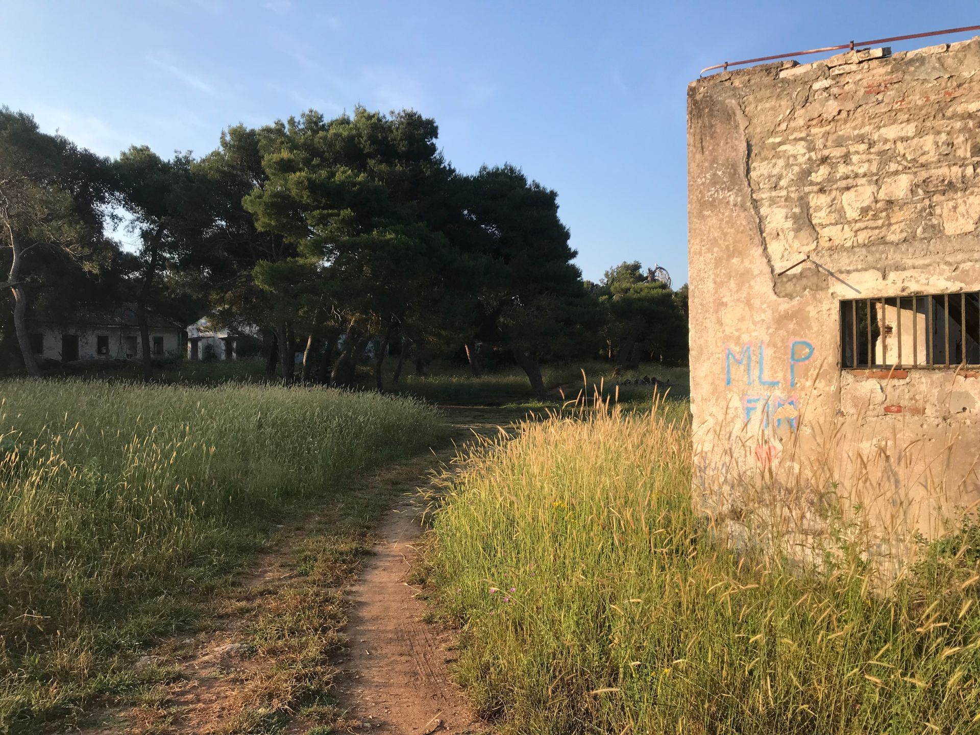 Ein Feldweg führt zu einem Gebäude, auf dem das Wort „Hilfe“ steht