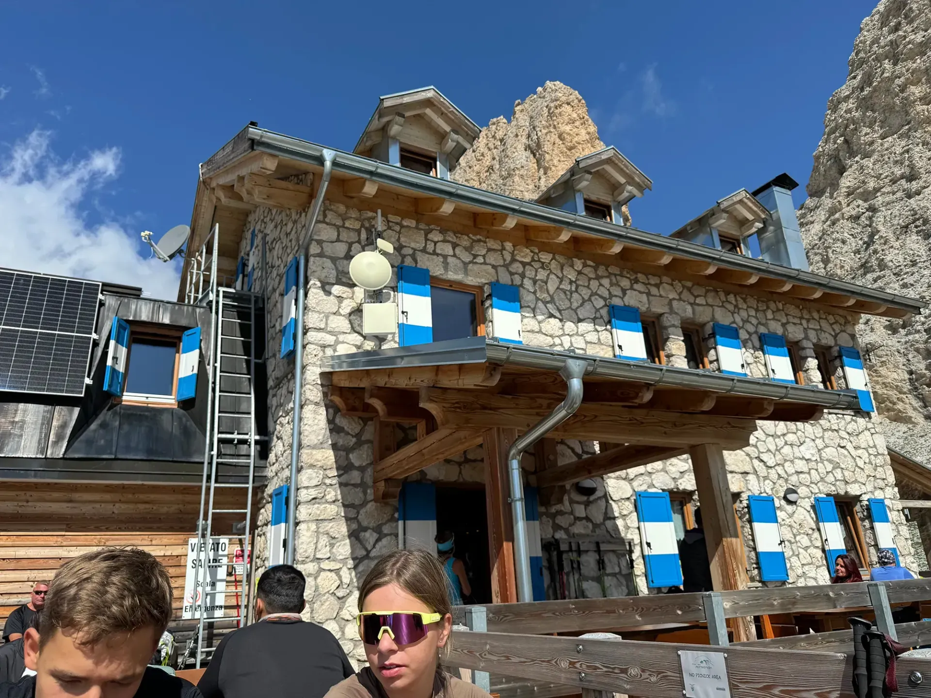 Eine Gruppe von Leuten sitzt vor einem Steingebäude.