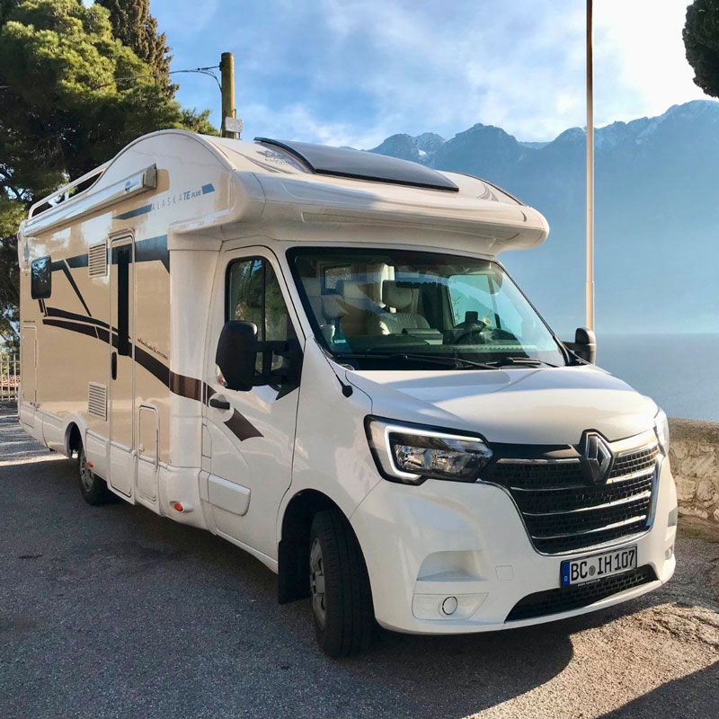 Ein weißes Wohnmobil steht am Straßenrand