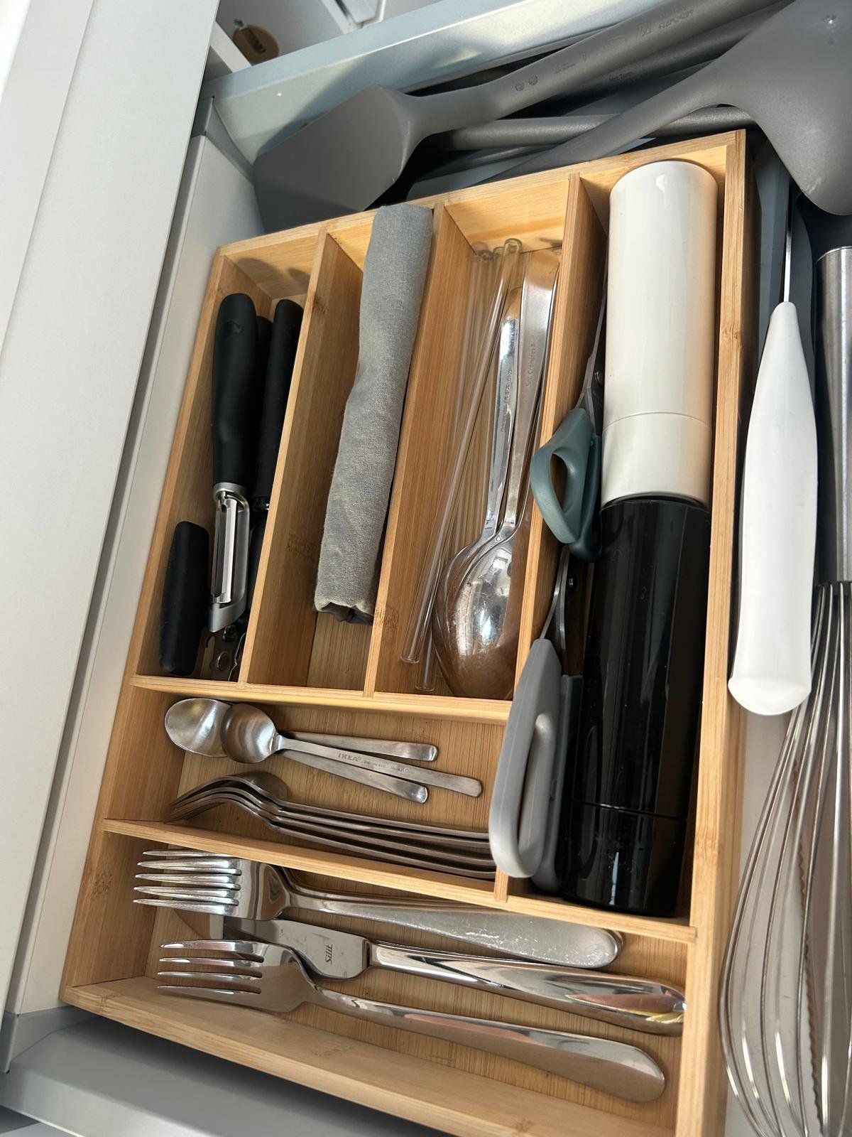 Eine Holzschublade voller Silberbesteck und Besteck.