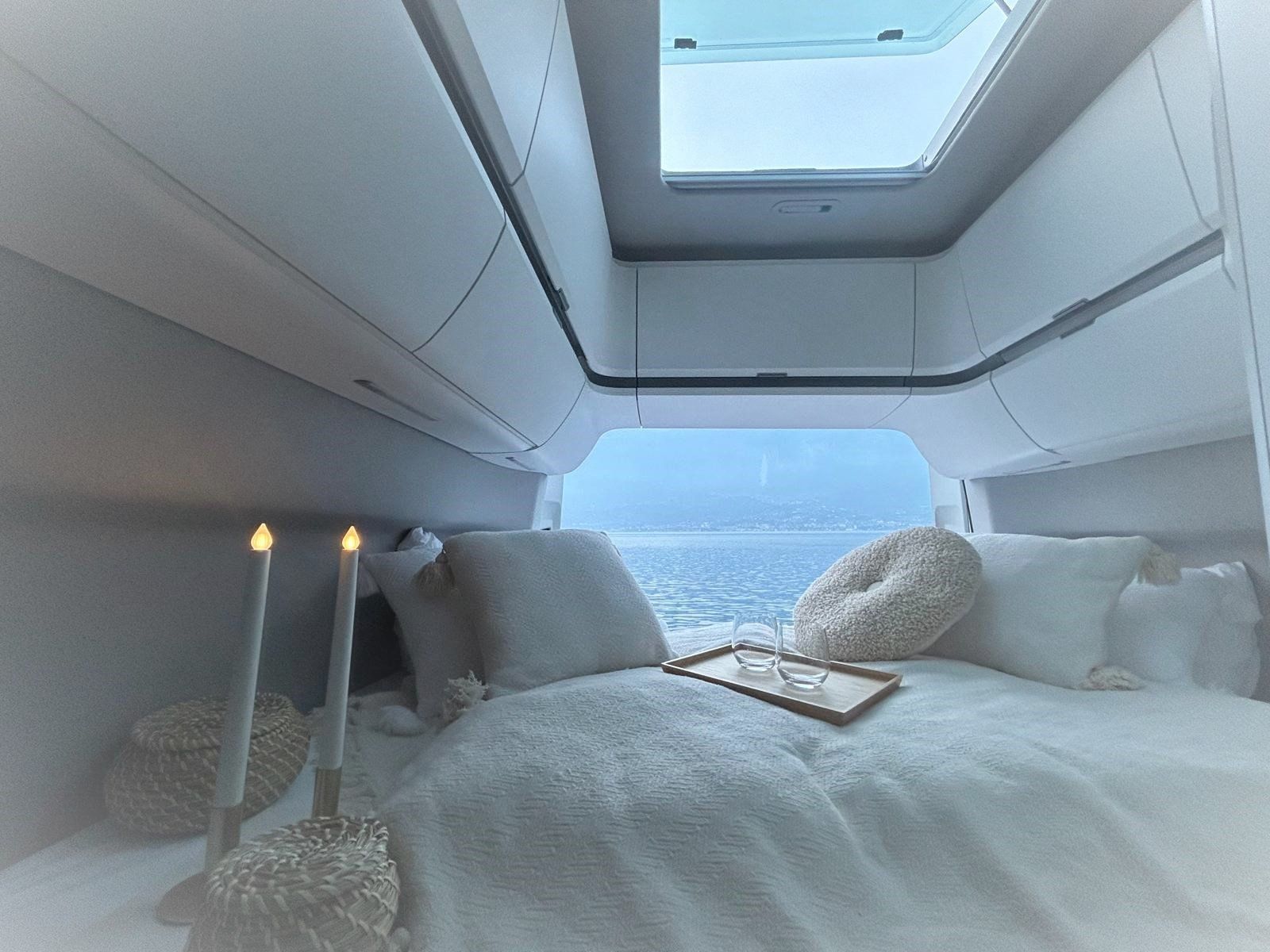 Ein Schlafzimmer mit Bett und Kerzen und Blick auf das Meer