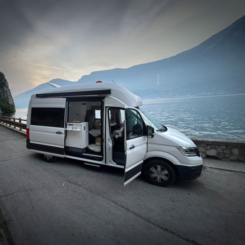 Ein weißer Lieferwagen steht mit offenen Türen am Straßenrand